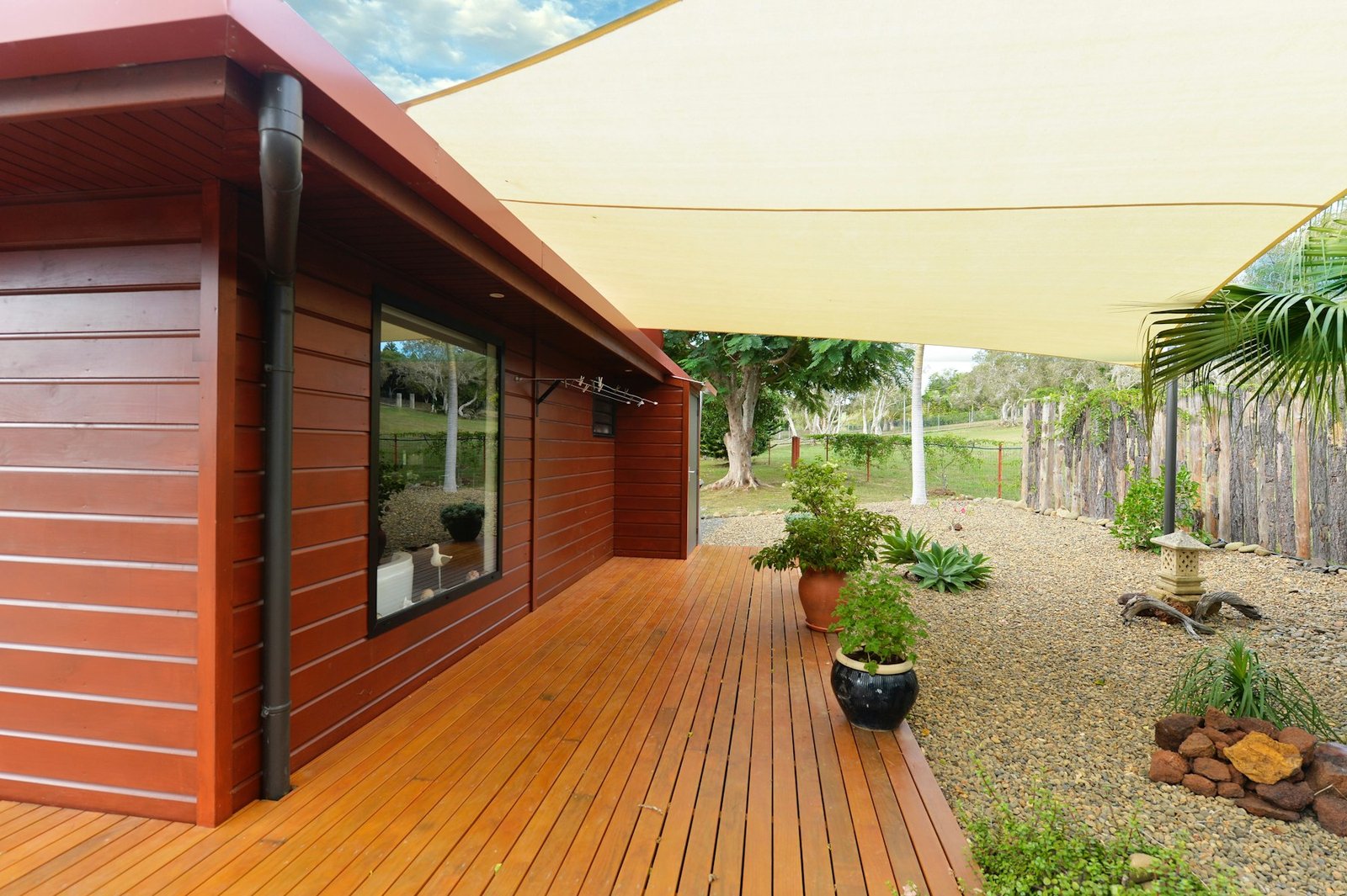Wood deck with a shade sail on a modern house